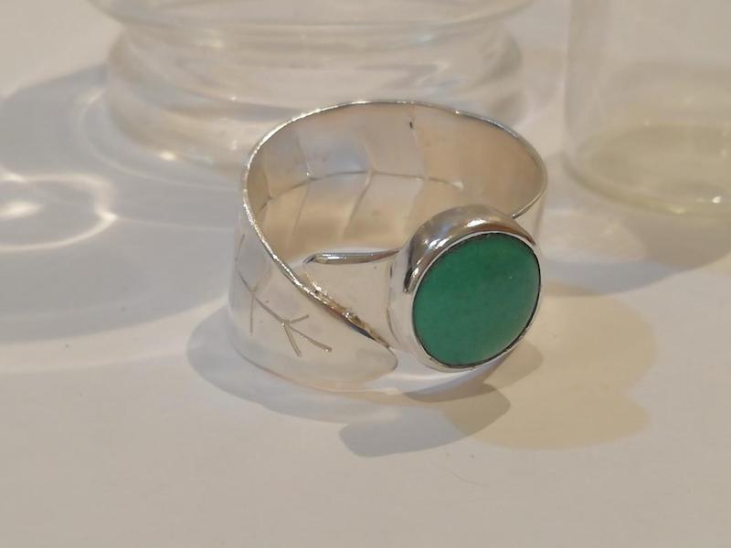 Anillo de plata con piedra verde y diseño de hojas Green stone silver ring in leaf design.