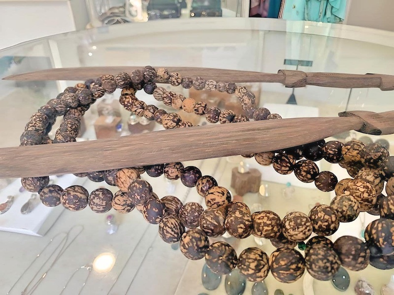 This photo features handcrafted wooden jewelry beads and decorative swords, created by local artists in Costa Rica. The beads display a unique marbled pattern, showcasing traditional craftsmanship.

Esta foto muestra cuentas de joyería de madera y espadas decorativas artesanales, creadas por artistas locales de Costa Rica. Las cuentas exhiben un patrón marmoleado único, reflejando la artesanía tradicional.