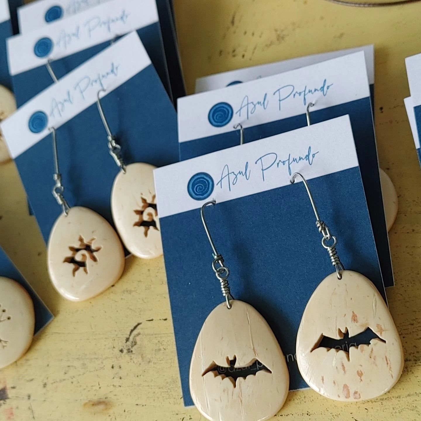 Carved cocnout shell earings with different symbols.